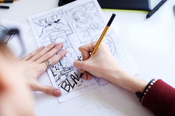 Mangaka qui dessine une planche de manga